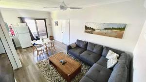 a living room with a couch and a table at Seaside Escape - 5 BR 2 Kitchens in Port Macquarie