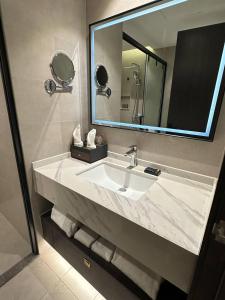 a bathroom with a sink and a large mirror at 巴域永源酒店 in Phumĭ Bavĕt (2)