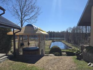 a wooden gazebo next to a pond at Kamienny Gościniec in Kopanica