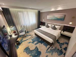 a large hotel room with a large bed and a room at 巴域永源酒店 in Phumĭ Bavĕt (2)