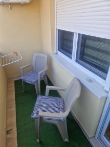 two chairs and a bench in a room with a window at Apartman Mina in Požarevac
