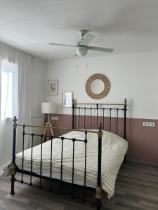 una camera da letto con un letto e un ventilatore a soffitto di Maison 3 chambres, piscine privée terrain de pétanque a Carcassonne