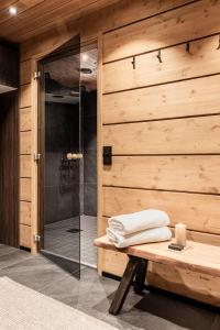 a bathroom with a shower and a wooden wall at Villa Draivi B By Hilla Villas - 3BR and alcove in Kittilä