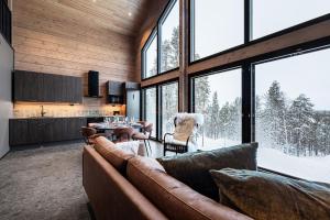 a living room with a couch and a table at Villa Draivi B By Hilla Villas - 3BR and alcove in Kittilä