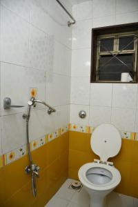 a bathroom with a toilet and a window at Aroma Villa lonavala in Lonavala
