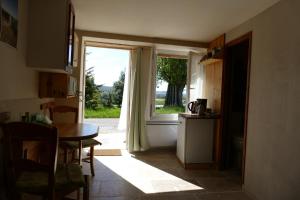 a kitchen with a table and a large window at Les bois rouges in La Rochegiron