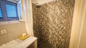 イドラにあるLuljeta's Guest Houseのタイル張りの壁のバスルーム(シャワー付)