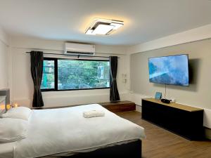 a bedroom with a large bed and a flat screen tv at Berlin Haus - CONSTRUCTION มีการก่อสร้าง - LOUD NOISE in Nonthaburi