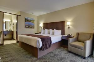 a hotel room with a large bed and a chair at Vagabond Inn Bishop in Bishop +23 photos