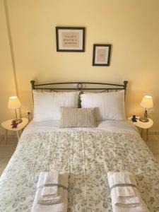 a bedroom with a large bed with towels on it at Nav Apart 2, Salamina in Paloúkia