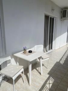 a white table and chairs with a plant on it at Nav Apart 2, Salamina in Paloúkia +20 photos