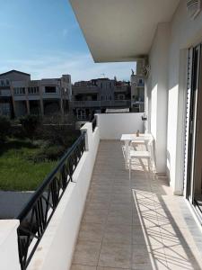 a balcony with a table and a view of a city at Nav Apart 2, Salamina in Paloúkia