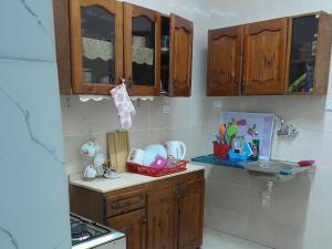 a kitchen with wooden cabinets and a counter top at yaso apartment in Cairo +32 photos