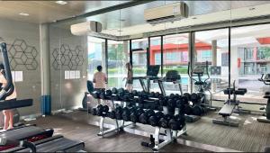 a gym with several tread machines and a person in the background at D Condo phuket kathu- patong in Amphoe Kathu