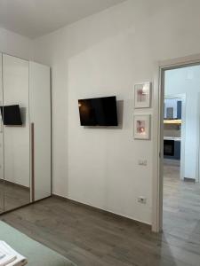 une pièce blanche avec une télévision sur un mur dans l'établissement B&B due stanzulelle, à Salerne