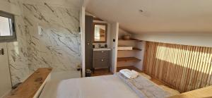a bedroom with a bed and a marble wall at Appartement de charme sur golf in Buzet-sur-Tarn