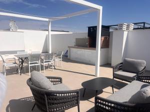 a patio with chairs and tables and a table and chairs at Villa Buba in Pilar de la Horadada