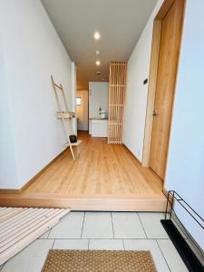 a room with a hallway with a door and wooden floors at hotel kusanagi in Nanao