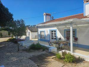 a small white house with a table and chairs at Casa Paloma in Comporta +24 photos
