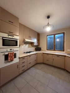 una grande cucina con elettrodomestici bianchi e una finestra di Maison 3 chambres, piscine privée terrain de pétanque a Carcassonne