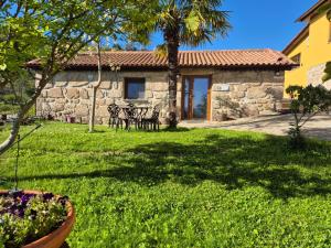 a house with a yard with a table and chairs at Quinta do Limite - Casa do Camponês in Covilhã