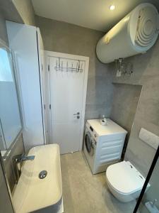 a bathroom with a washing machine and a washer at City Center Deluxe in Durrës +39 photos