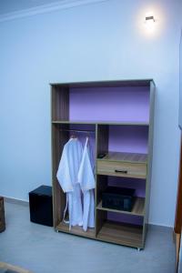 une armoire avec des vêtements suspendus dans une pièce dans l'établissement Rond Point Gorilla Boutique and Apartments, à Ruhengeri