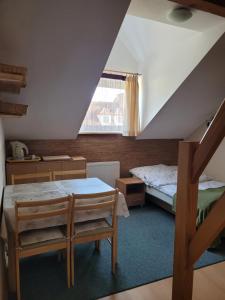 a attic room with a bed and a table at Pokoje Gościnne u Stasi in Mielno