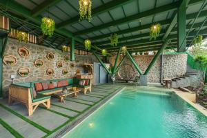 ein Pool mit Stühlen und ein Sofa neben einem Haus in der Unterkunft SaffronStays Shambhala Bodhi - 3-BR villa overlooking Pawna Lake with private pool, jacuzzi, and lounge areas in Malavli