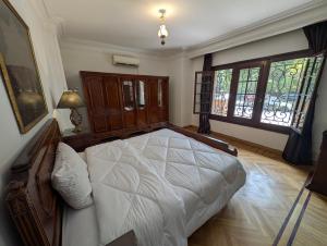 a bedroom with a large bed and windows at Villa Maadi - 35 - R 1 Street view Room in Cairo +35 photos