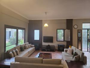 a living room with couches and a flat screen tv at Bahga villa in Alexandria