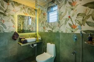 ein Badezimmer mit Toilette, Waschbecken und Spiegel in der Unterkunft SaffronStays Shambhala Bodhi - 3-BR villa overlooking Pawna Lake with private pool, jacuzzi, and lounge areas in Malavli + 11 Fotos