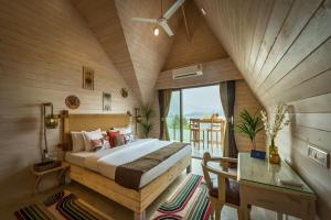 ein Schlafzimmer mit einem Bett in einem Zimmer mit Fenster in der Unterkunft SaffronStays Shambhala Bodhi - 3-BR villa overlooking Pawna Lake with private pool, jacuzzi, and lounge areas in Malavli