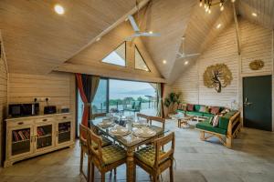 ein Wohnzimmer mit einem Tisch und einem Sofa in der Unterkunft SaffronStays Shambhala Bodhi - 3-BR villa overlooking Pawna Lake with private pool, jacuzzi, and lounge areas in Malavli