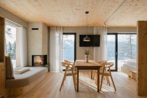 ein Zimmer mit Esstisch, Bett und Kamin in der Unterkunft Chalet Herol in Lüsen