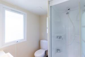 une salle de bain avec toilettes et douche en verre dans l'établissement Mobilhome O’Hara 734T, à Bouzic 15 autres photos