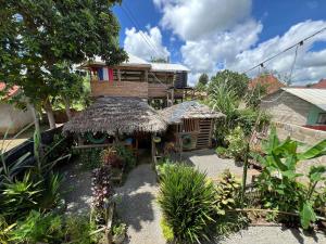 a small house with a straw roof in a garden at Karibu Eco-Hostel Arusha in Arusha