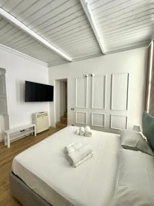 a white bedroom with a large bed with towels on it at Portobello In Centro in Salerno +14 photos