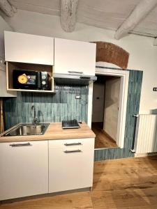 a kitchen with white cabinets and a sink at Portobello In Centro in Salerno