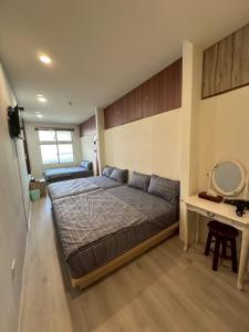 a bedroom with a bed and a desk and a mirror at 小琉球觀海洋客棧View Ocean Inn in Xiaoliuqiu