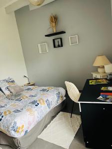 a bedroom with a bed and a desk with a chair at Maison entre Saumur et Montreuil Bellay La Motte in Artannes-sur-Thouet