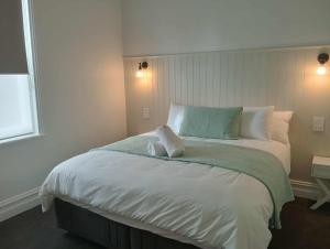 a bedroom with a large bed with a green blanket at Honeysuckle Inn - Violet Town in Violet Town +15 photos