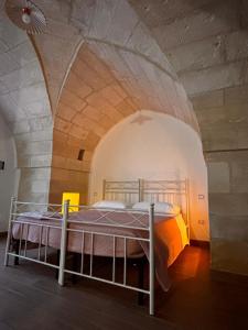 una camera con letto in una stanza ad arco di Uliveto Sant' Isidoro a Maglie