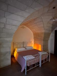 una camera da letto con un letto in un muro di pietra di Uliveto Sant' Isidoro a Maglie Altre 55 foto