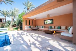 een patio met banken en een zwembad bij Villa les Palmiers in Marrakesh