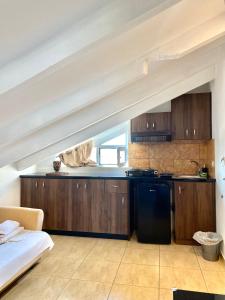 a kitchen with wooden cabinets and a black refrigerator at Villa Elva in Ammoudia