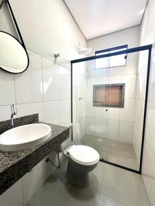 ein Badezimmer mit Toilette, Waschbecken und Spiegel in der Unterkunft Casa Davisis - PX da JK e Centro - Ate 8 Hospedes in Palmas + 17 Fotos