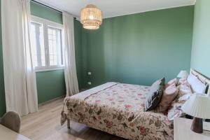 a bedroom with green walls and a bed at Casa Gaia - Villetta a pochi passi da Roma in Ciampino