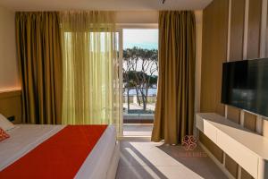 una camera da letto con un letto, una tv e una finestra di Hotel Skanderbeg a Golem