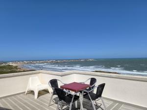 a table and chairs on a balcony overlooking the ocean at Baleal 4 Surf II in Baleal +21 photos